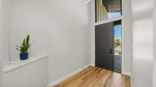 a view of a hallway with wooden floor and a window
