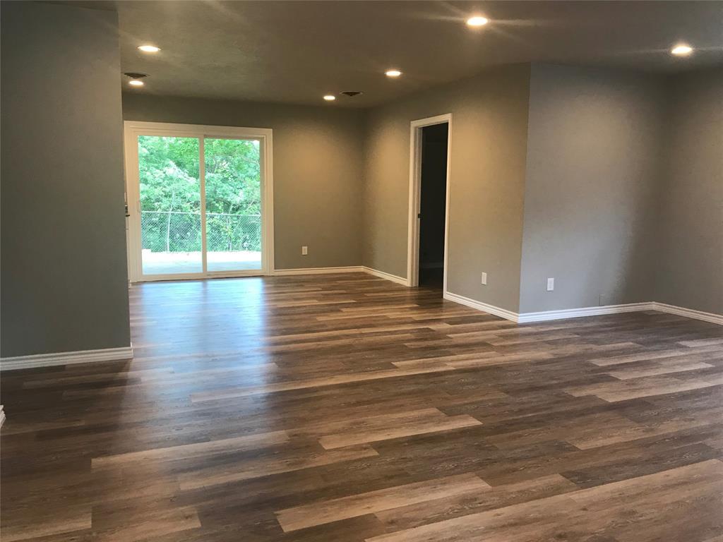 105 Oak Ridge Terrace Weatherford, TX 76086 - Photo 6 of 21 a view of an empty room with wooden floor and a window