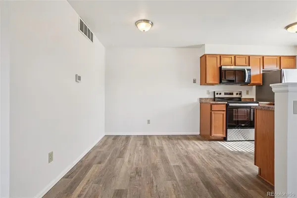 a view of empty room with wooden floor
