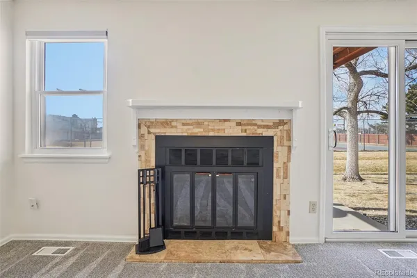 an empty room with windows and fireplace