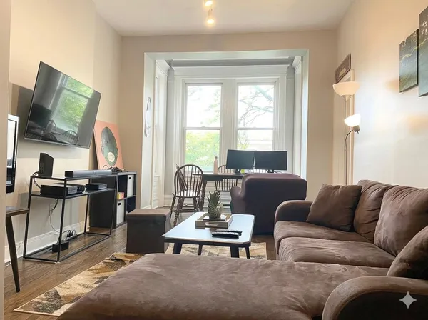 a living room with furniture wooden floor and a flat screen tv