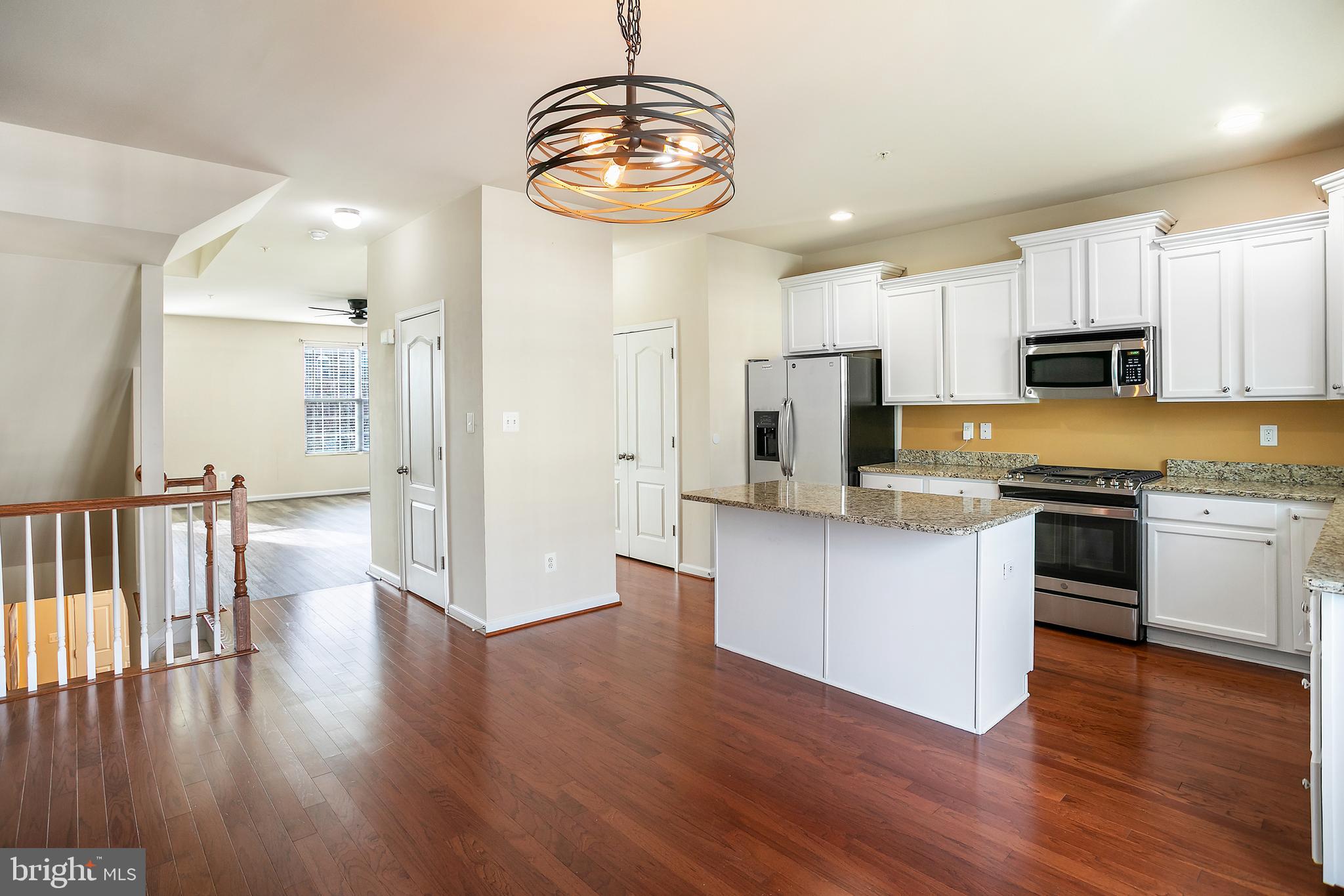 2885 Falkirk Alley Bryans Road, MD 20616 - Photo 14 of 43 a kitchen with stainless steel appliances granite countertop a refrigerator a stove top oven a sink dishwasher and white cabinets with wooden floor