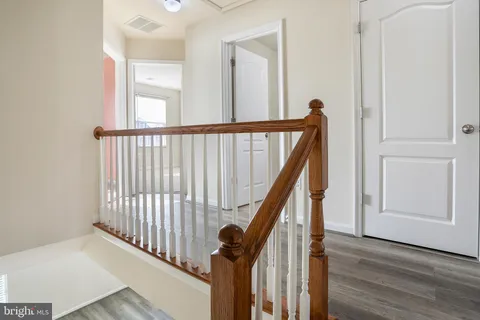 a view of a hallway with wooden floor and staircase