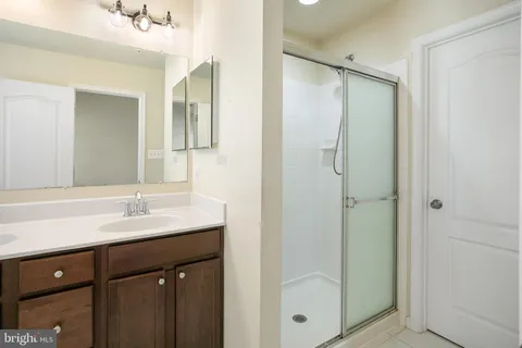 a bathroom with a shower sink and mirror