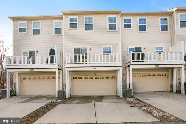 a front view of a building with a garage and parking space