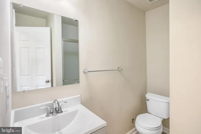 a bathroom with a sink a toilet and a mirror