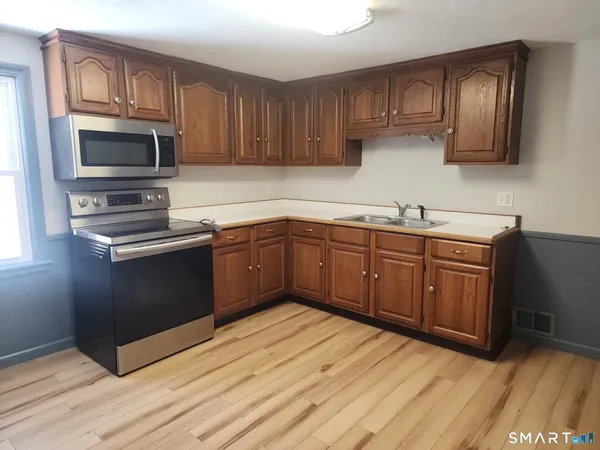 a kitchen with stainless steel appliances granite countertop a sink stove and microwave