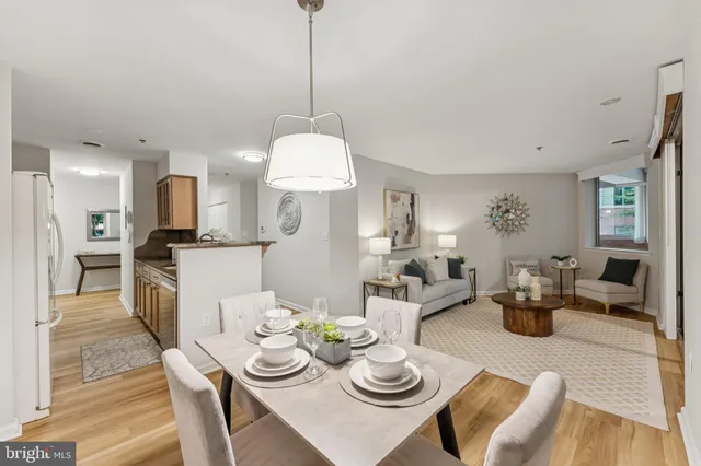 a view of a dining room and livingroom with furniture wooden floor a chandelier