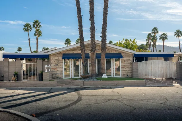 a view of a white house with a outdoor space and garden
