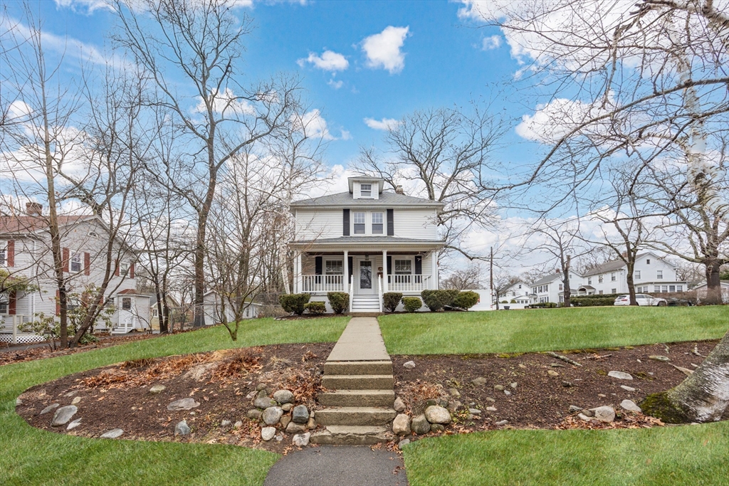 a front view of a house with a yard and green space