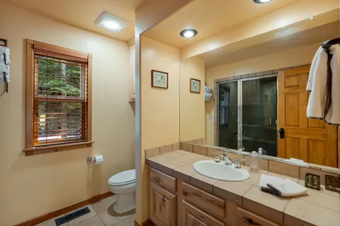 a bathroom with a granite countertop toilet sink and a mirror