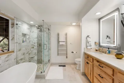 a bathroom with a double vanity sink toilet mirror and bathtub