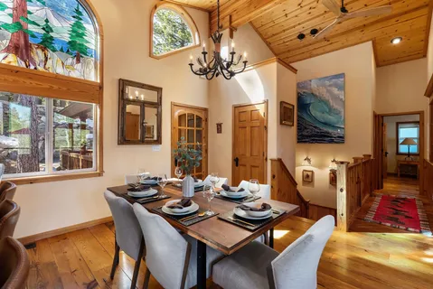 a view of a dining room with furniture a chandelier and wooden floor