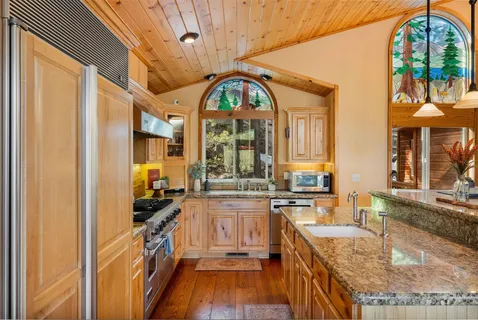 a kitchen with stainless steel appliances granite countertop a stove a sink and a refrigerator