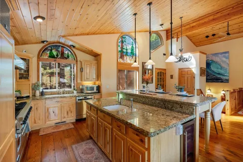a kitchen with stainless steel appliances granite countertop a stove and a wooden floors