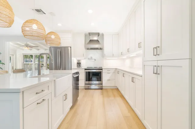 a large white kitchen with cabinets