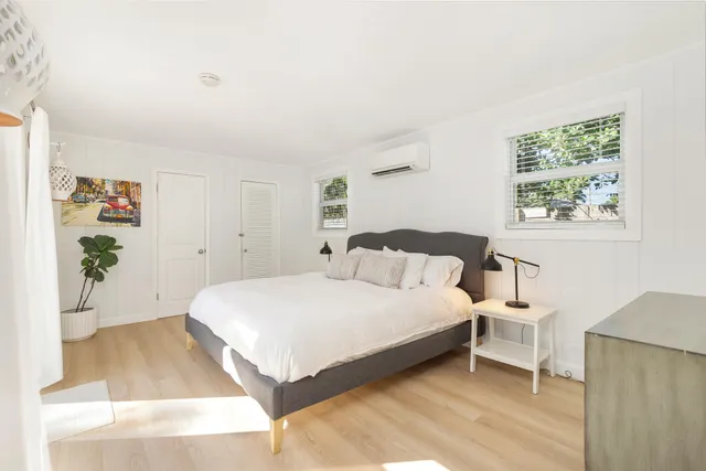 a spacious bedroom with a bed and a painting on the wall