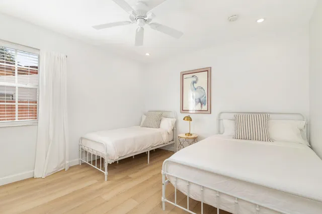 a bedroom with two beds and a window