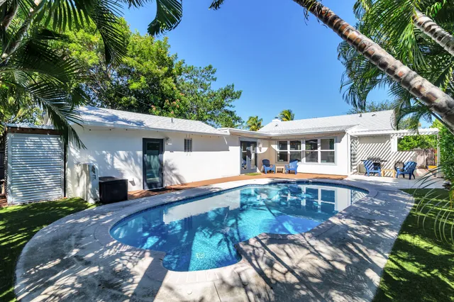 a view of a house with swimming pool and sitting area