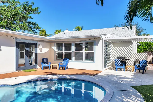 a view of a house with backyard and sitting area