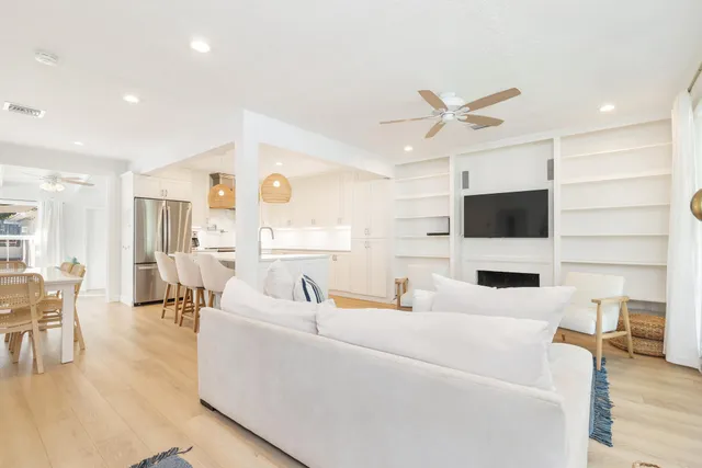 a living room with furniture a flat screen tv and kitchen view