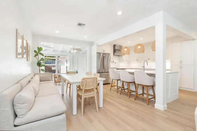 a dining room with furniture a floor to ceiling window and wooden floor