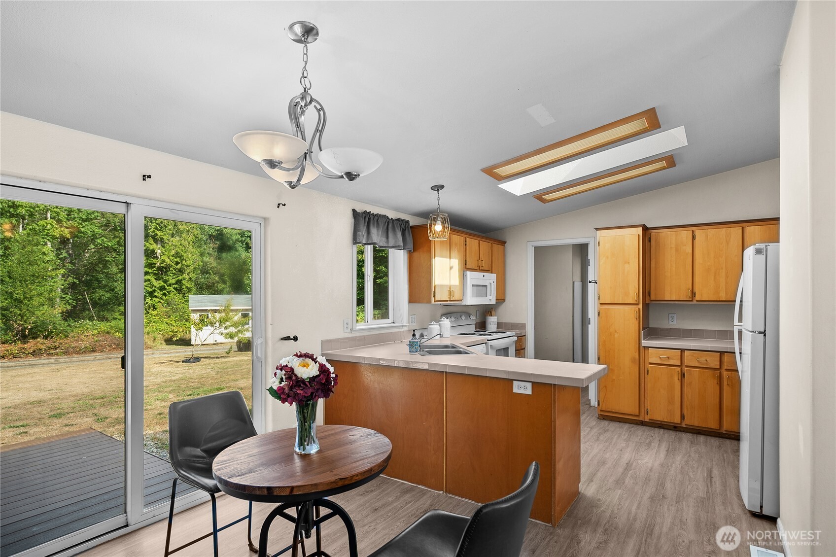 1870 Northwest Vaa Road Poulsbo, WA 98370 - Photo 13 of 40 a dining room with furniture a chandelier and wooden floor