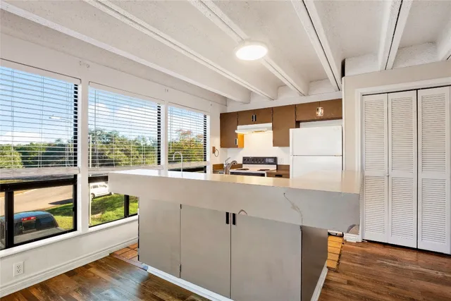 a kitchen with stainless steel appliances a refrigerator a sink and wooden cabinets