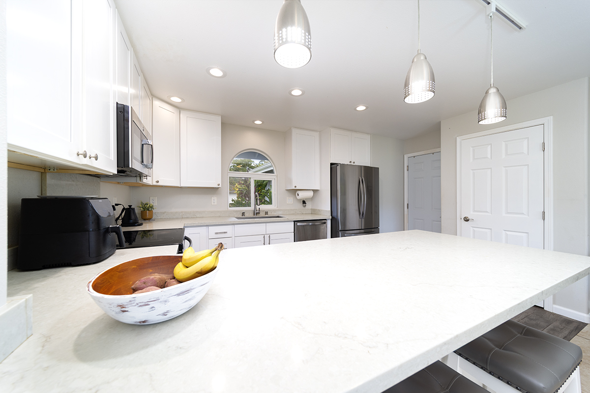 189 Noelani Loop, Unit 1 Hilo, HI 96720 - Photo 8 of 29 a kitchen with a table chairs and refrigerator