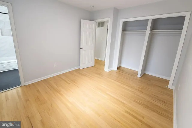 a view of empty room with wooden floor and entryway