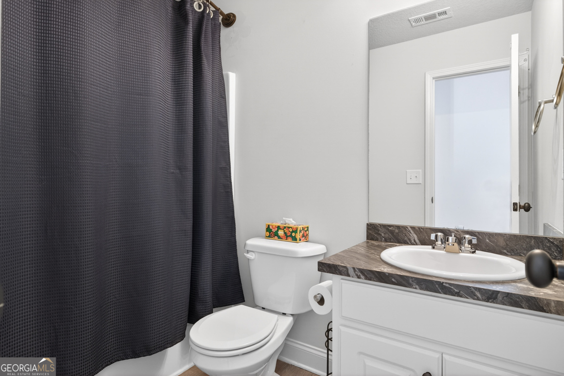 142 Rolling Wds Lane, Unit 29 Colbert, GA 30628 - Photo 11 of 34 a bathroom with a sink a toilet a mirror and shower curtain