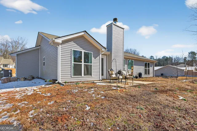 a front view of a house with a yard and seating space