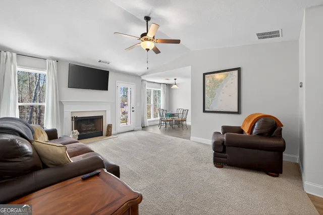 a living room with furniture a flat screen tv and a fireplace