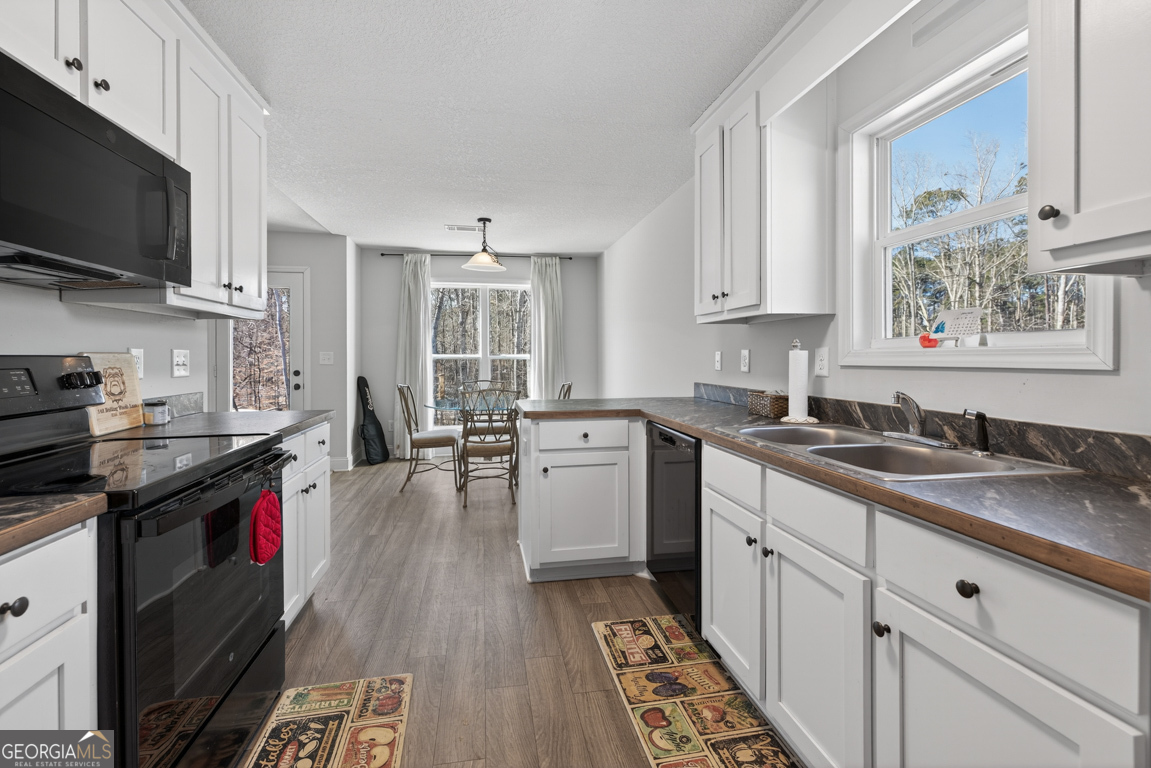 142 Rolling Wds Lane, Unit 29 Colbert, GA 30628 - Photo 23 of 34 a kitchen with a sink stove and cabinets