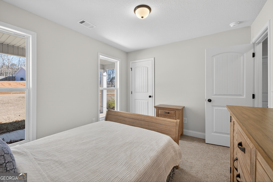 142 Rolling Wds Lane, Unit 29 Colbert, GA 30628 - Photo 26 of 34 a bedroom with a bed and a cabinets
