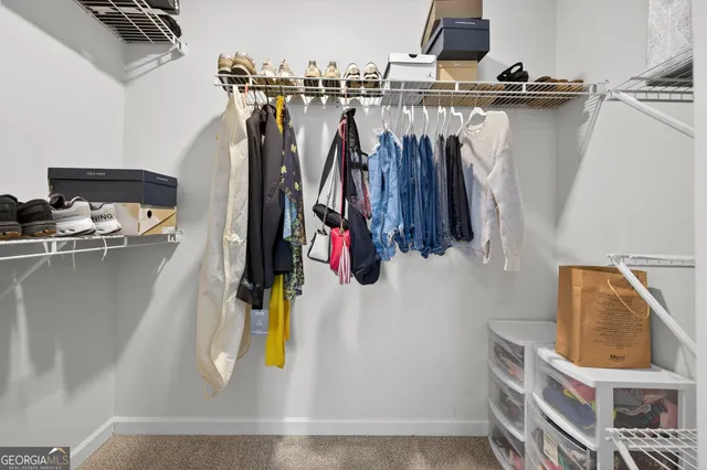 a view of walk in closet with clothes and shoes