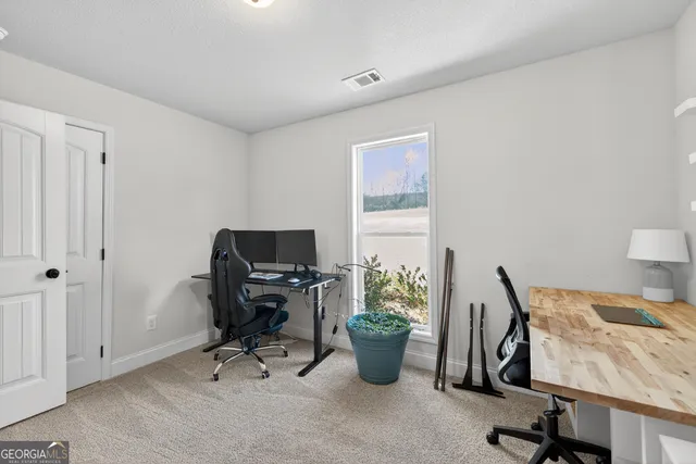 a view of a workspace with furniture and a window