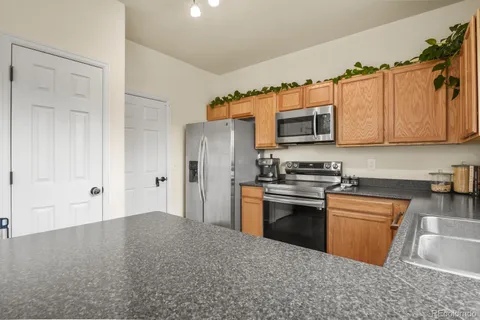 a kitchen with granite countertop a sink stove and refrigerator