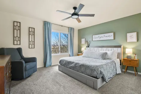 a bedroom with a bed a couch and a ceiling fan