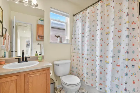 a bathroom with a granite countertop sink a toilet and a mirror