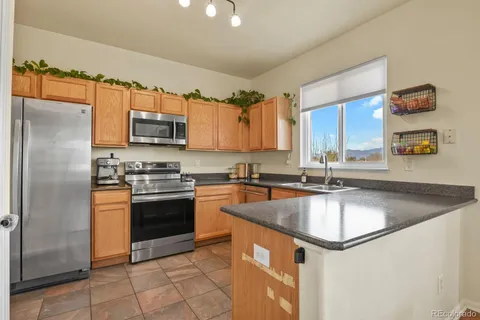 a kitchen with stainless steel appliances granite countertop a sink stove refrigerator and microwave