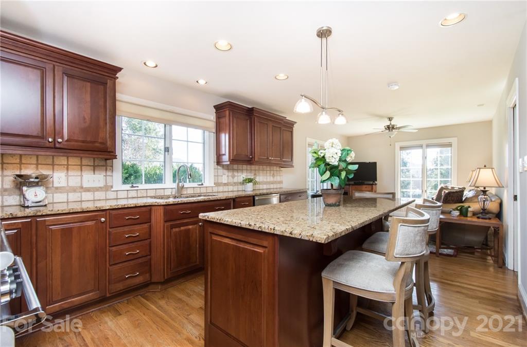 6955 Old Providence Road Charlotte, NC 28226 - Photo 13 of 44 a kitchen with granite countertop lots of counter space dining table and stainless steel appliances