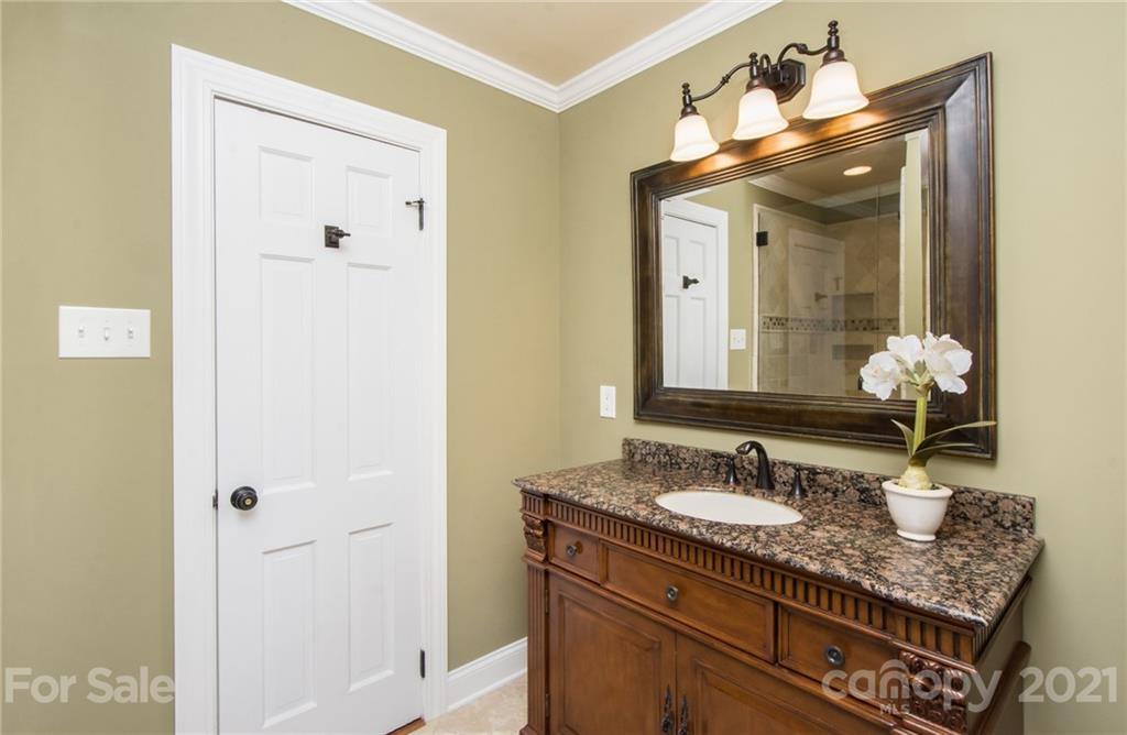 6955 Old Providence Road Charlotte, NC 28226 - Photo 24 of 44 a bathroom with a granite countertop sink a mirror and a shower