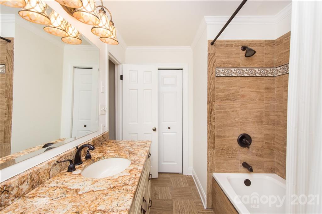 6955 Old Providence Road Charlotte, NC 28226 - Photo 28 of 44 a bathroom with a tub sink and mirror