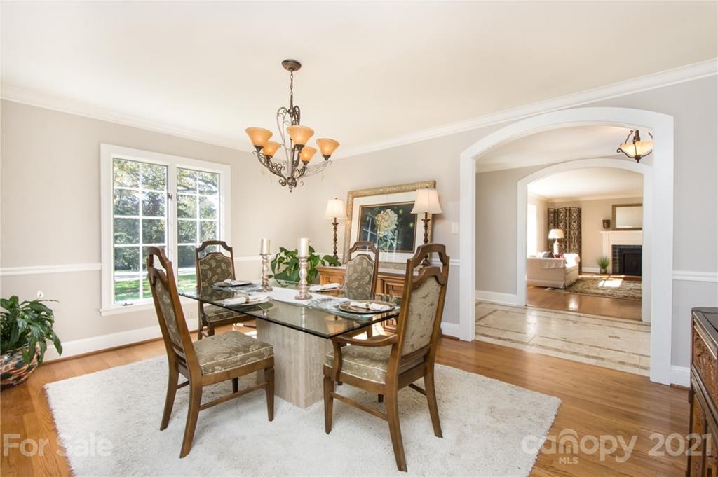 6955 Old Providence Road Charlotte, NC 28226 - Photo 8 of 44 a dining room with furniture wooden floor a potted plant and a chandelier