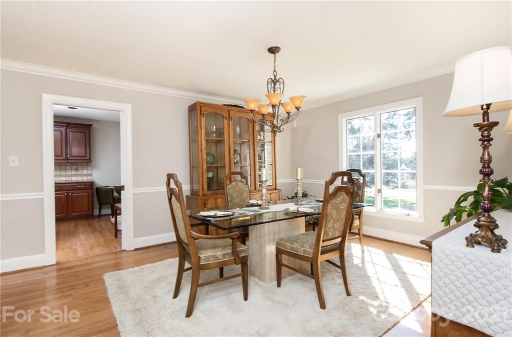 6955 Old Providence Road Charlotte, NC 28226 - Photo 9 of 44 a dining room with furniture a chandelier and wooden floor