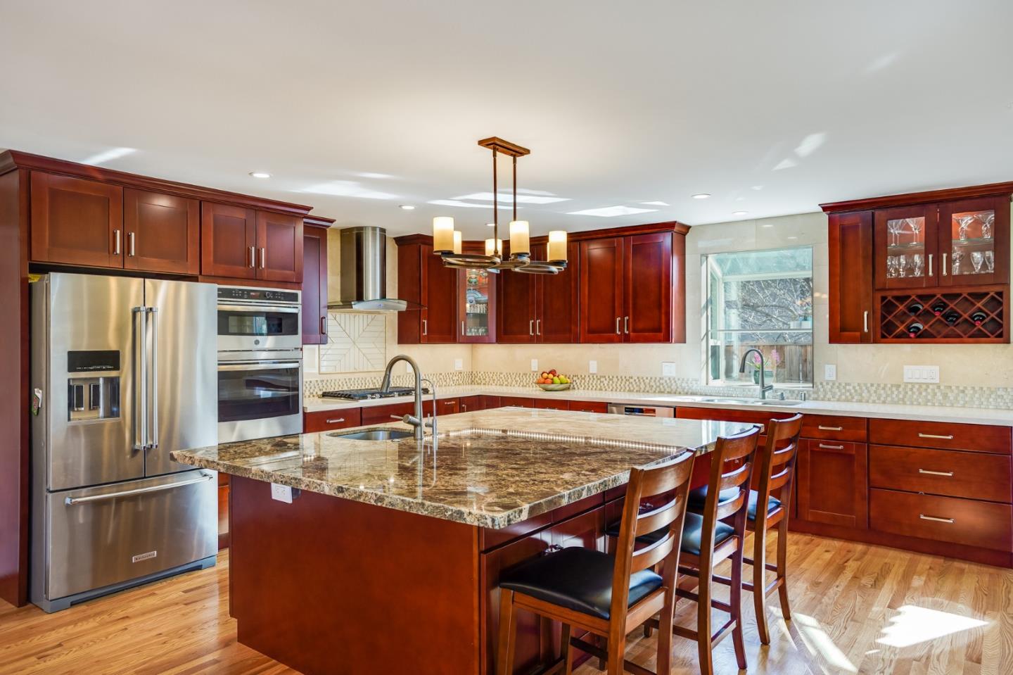 a kitchen with stainless steel appliances granite countertop a kitchen island a stove and a sink