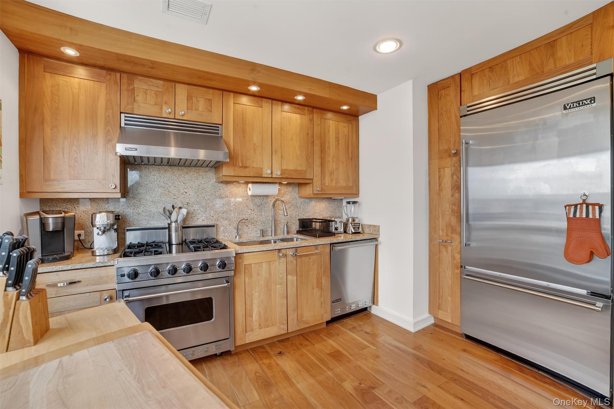 5 Renaissance Square, Unit 26E White Plains, NY 10601 - Photo 5 of 21 a kitchen with stainless steel appliances a stove a sink and a refrigerator
