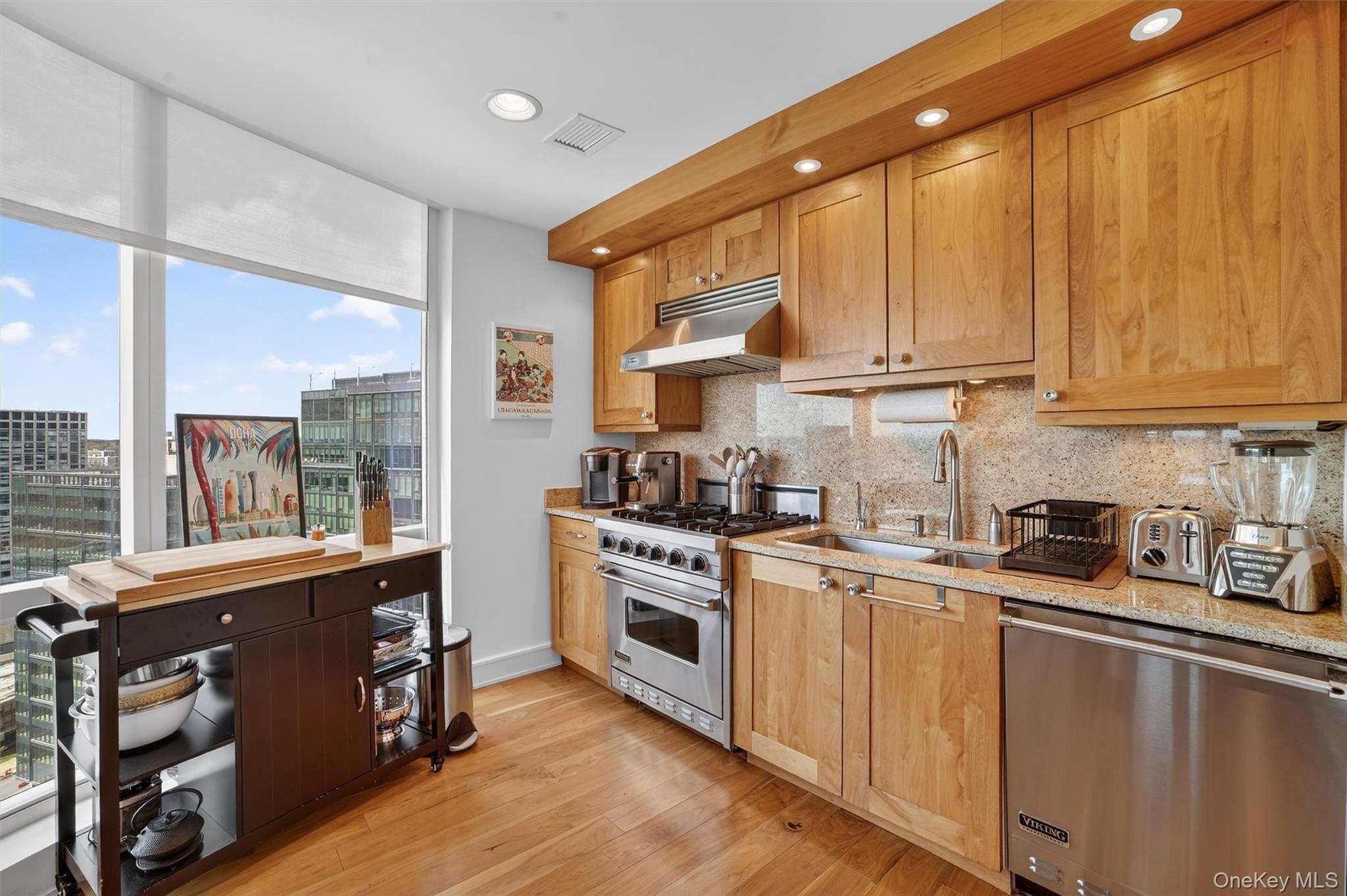 5 Renaissance Square, Unit 26E White Plains, NY 10601 - Photo 6 of 21 a kitchen with stainless steel appliances granite countertop a stove a sink and a microwave