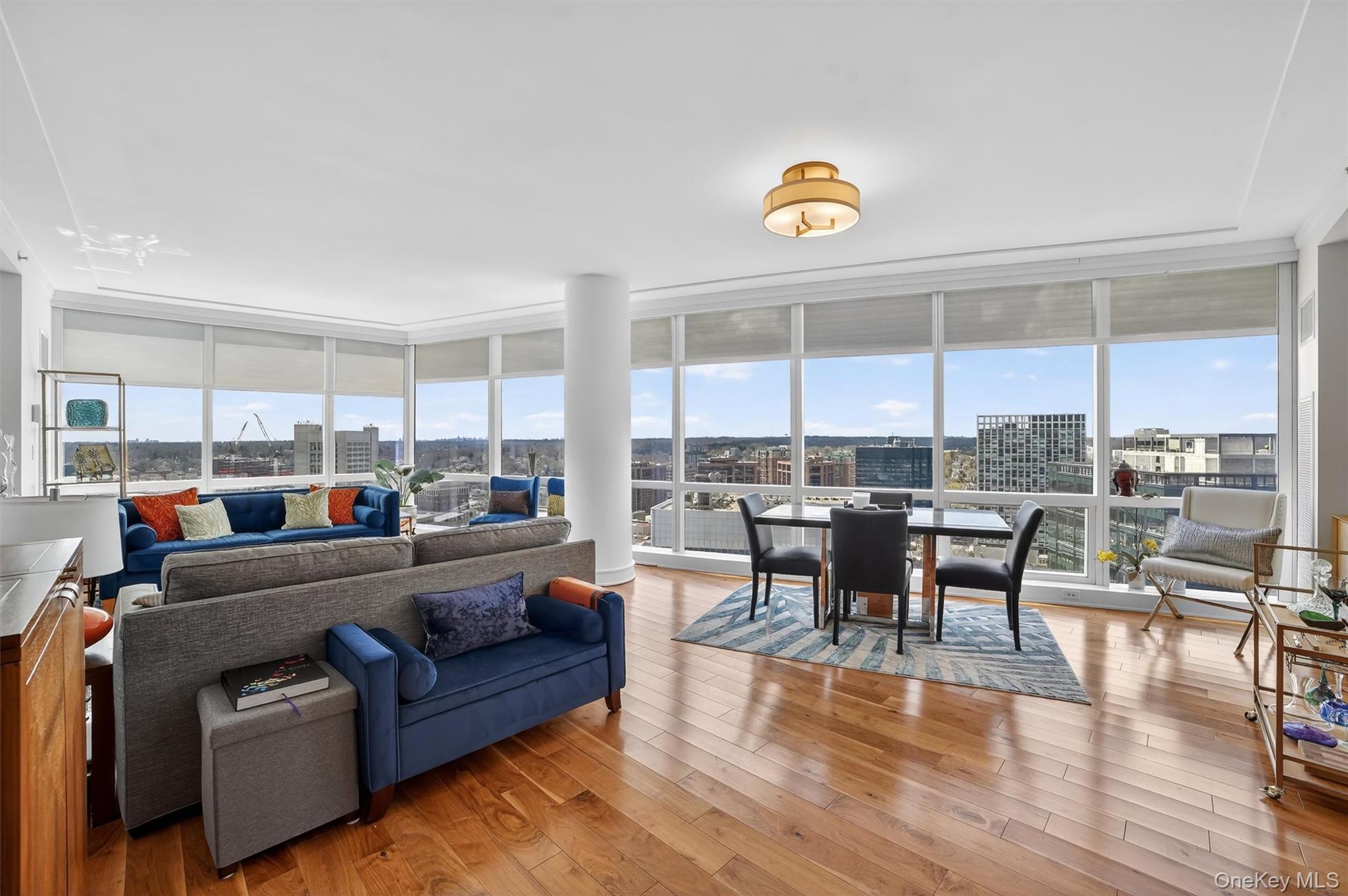 5 Renaissance Square, Unit 26E White Plains, NY 10601 - Photo 10 of 21 a living room with furniture a dining table and a floor to ceiling window